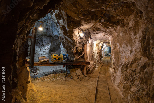 Exploring an abandoned underground mine in the mountains with machinery and tracks 