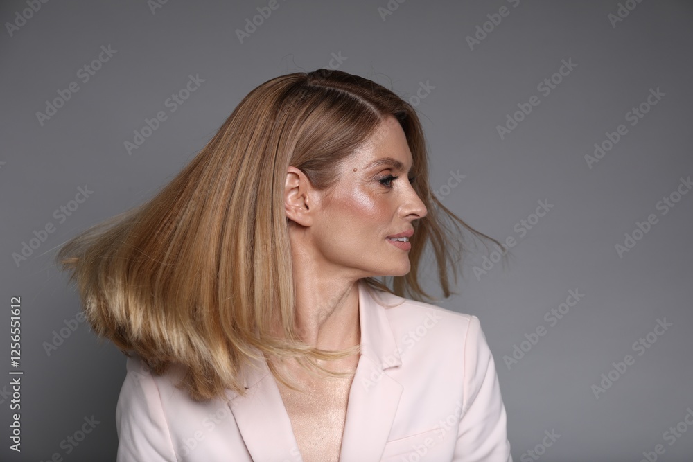 Portrait of beautiful woman with straight blonde hair on grey background Portrait of beautiful woman with straight blonde hair on grey background