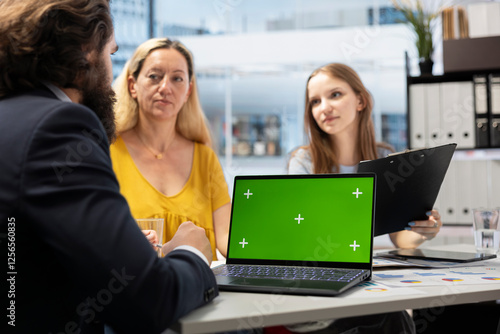 Financial advisor showing data graphs on green screen notebook to customers, analyzing market trends to do forecasting. Clients checking investment plan on chroma key laptop