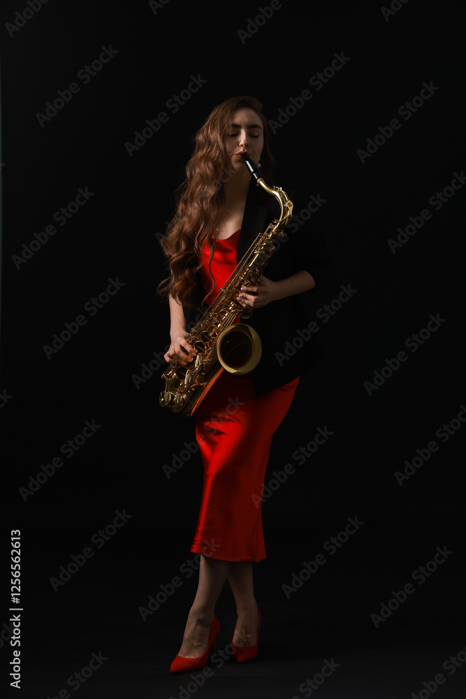 Obraz premium Professional musician playing saxophone on black background