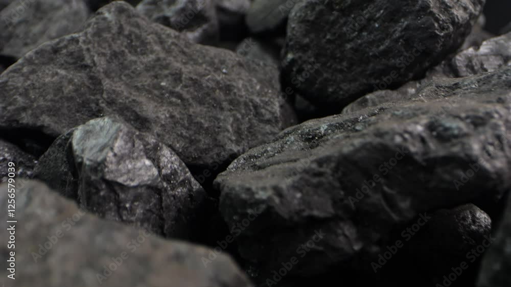 Close-up of coal fragments shifting slowly. A detailed macro shot for energy-themed presentations or videos about black coal resources. Close-up of coal fragments shifting slowly. A detailed macro shot for energy-themed presentations or videos about black coal resources.