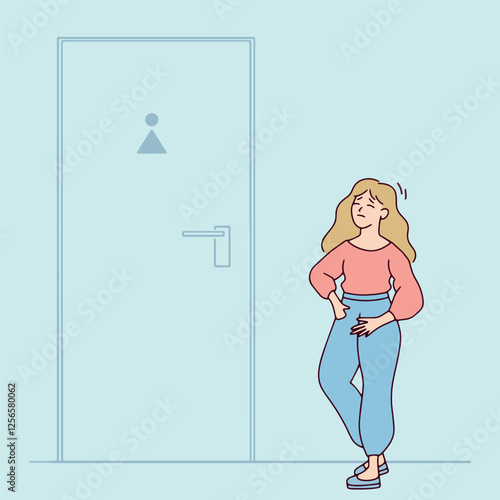 Young blonde woman with long hair stands near a toilet door, appearing uncomfortable. She is urgently waiting