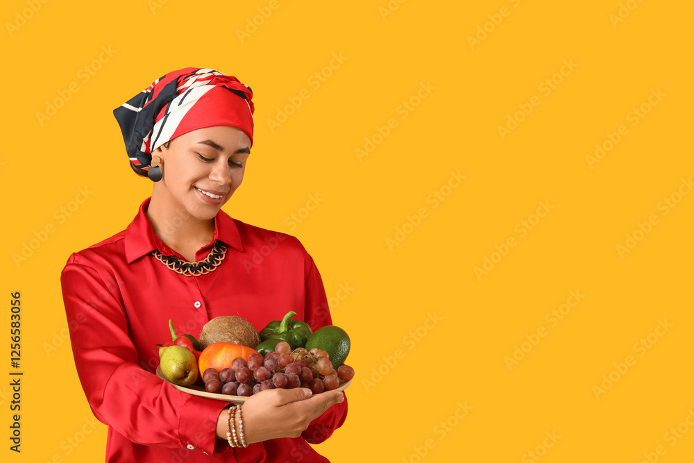 Young African-American woman with tasty food on yellow background. Kwanzaa celebration Young African-American woman with tasty food on yellow background. Kwanzaa celebration