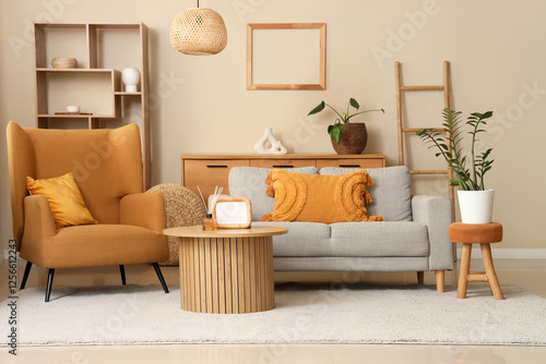 Interior of living room with comfortable sofa, armchair and table near beige wall