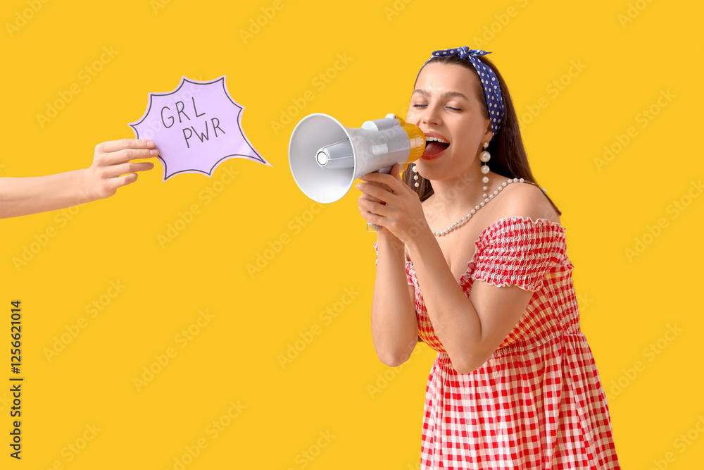 Young pin-up woman screaming into megaphone and female hand with GRL PWR sign on yellow background. Women's History Month Young pin-up woman screaming into megaphone and female hand with GRL PWR sign on yellow background. Women's History Month