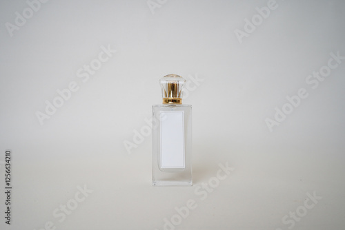 Front-facing perfume bottle with a gold cap and blank white label, set against a neutral background. Ideal for branding mockups, cosmetic product visuals, and luxury fragrance concepts.