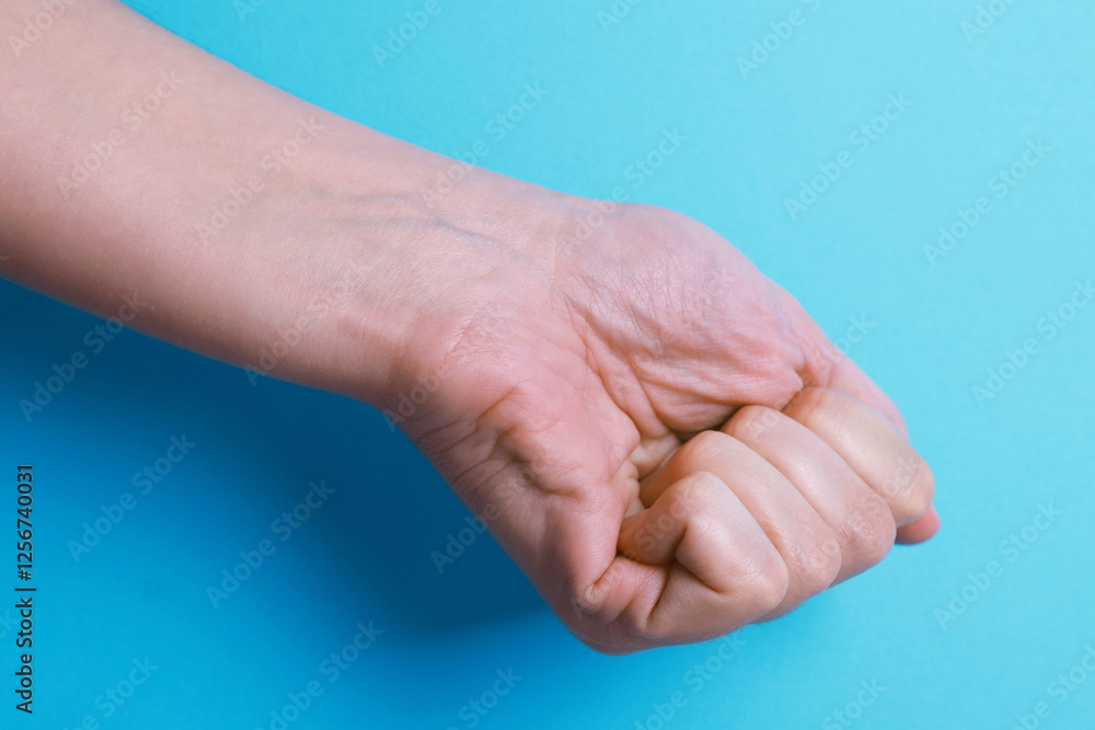 Woman with visible hand veins on light blue background, closeup