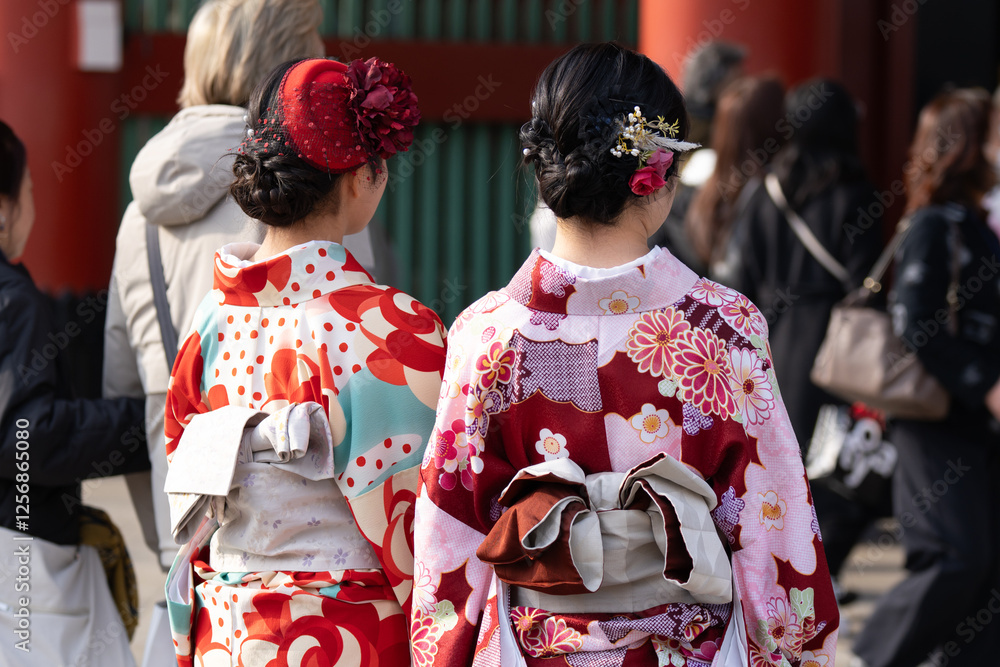 Fototapeta premium Young girl wearing Japanese kimono standing in front of Sensoji Temple in Tokyo, Japan. Kimono is a Japanese traditional garment. The word