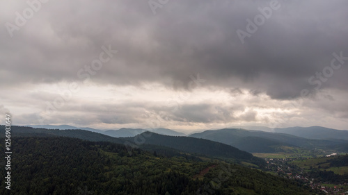 Magnificent Aerial View Of Mountains And Dense Forests Under Dark Clouds, With Raindrops Falling, Creating A Dramatic And Serene Atmosphere In A Remote Natural Landscape.	
