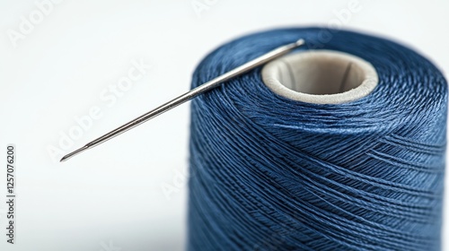 Close-up spool of navy blue thread with needle photo