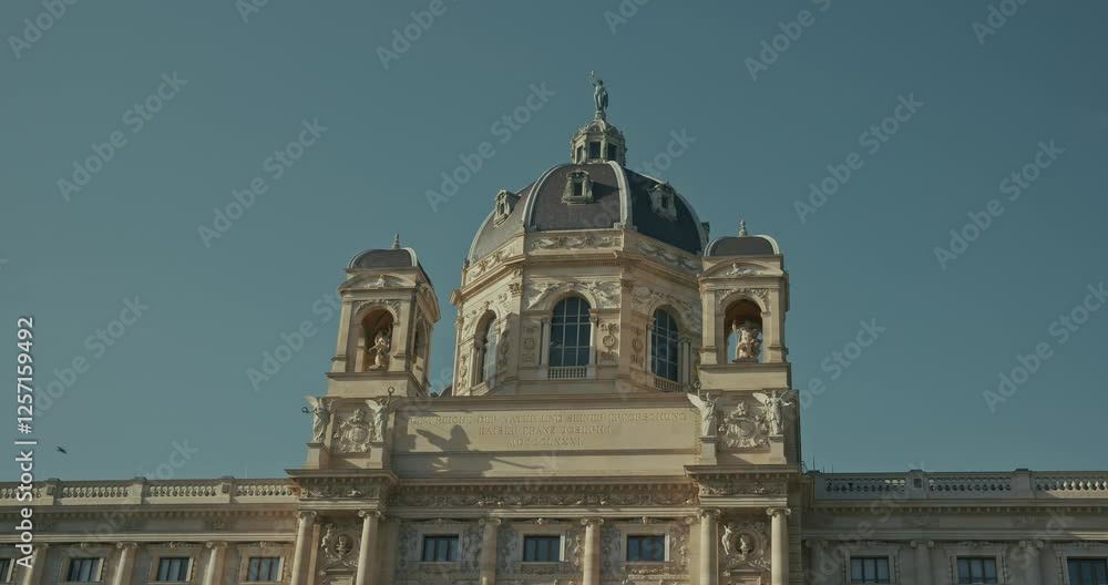 Ornate museum dome and statues under clear sky in Vienna, Austria Ornate museum dome and statues under clear sky in Vienna, Austria
