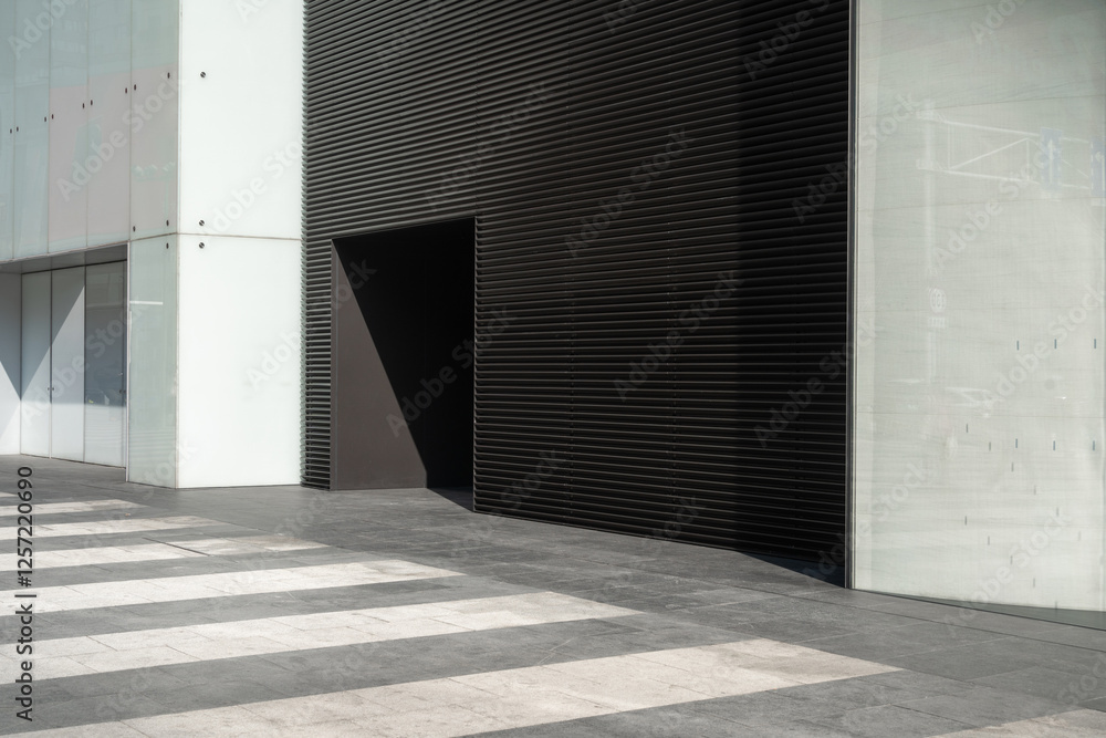 Obraz premium Modern building facade with large door and striped pavemen
