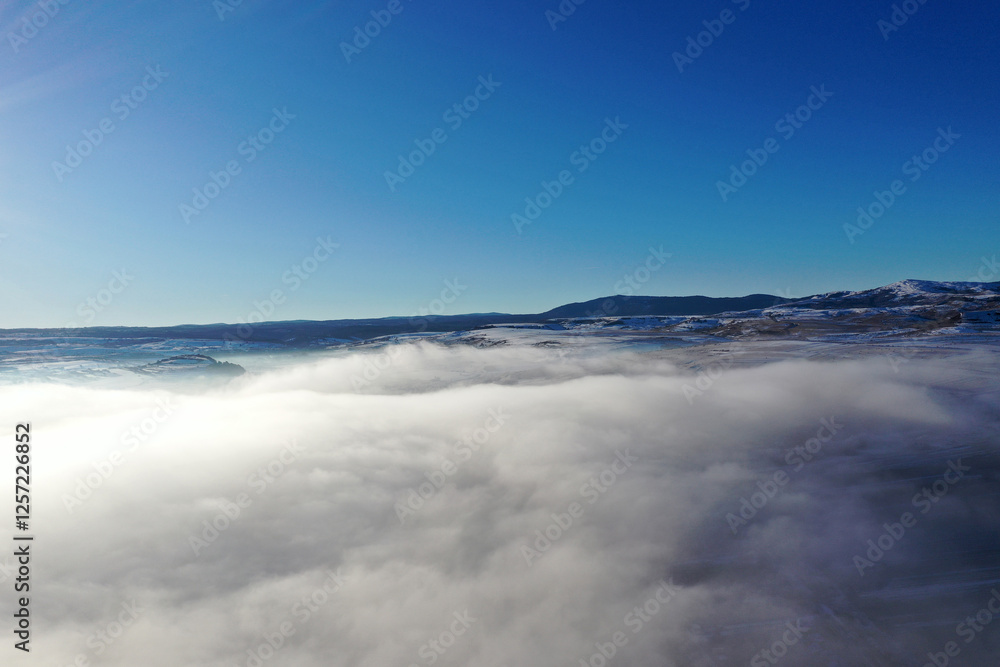 Aerial view of fog blankets during a bright winter morning under a clear blue sky Aerial view of fog blankets during a bright winter morning under a clear blue sky