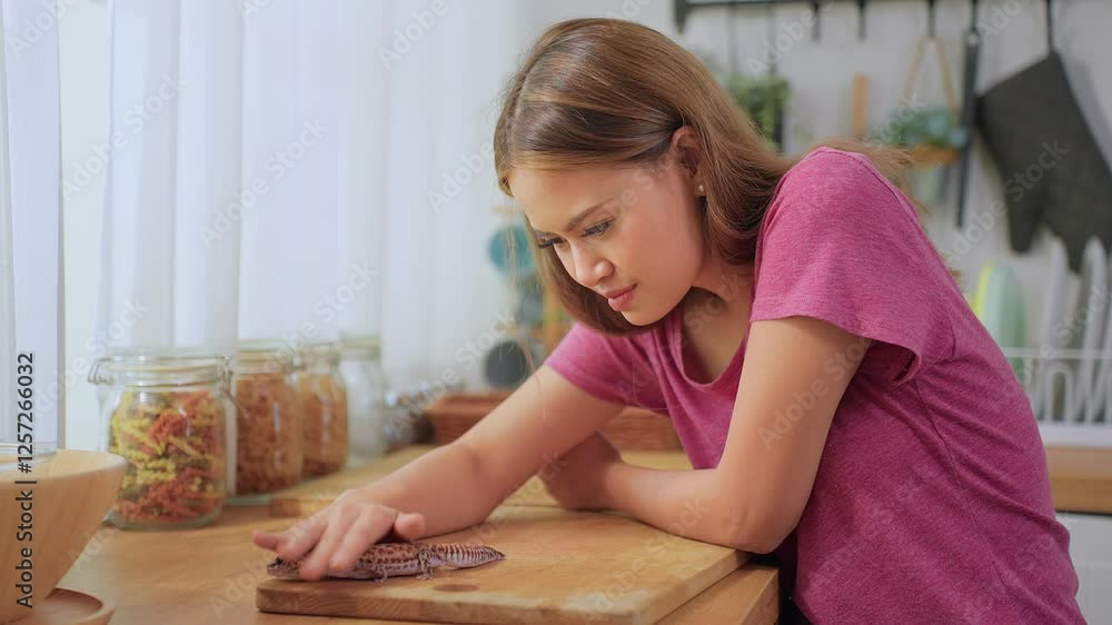 Asian young female owner play with her leopard gecko in kitchen at home. Asian young female owner play with her leopard gecko in kitchen at home.