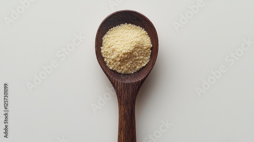 Wooden spoon holding yellow spice on white background photo