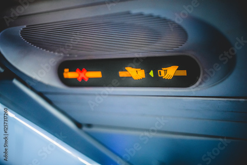 Illuminated fasten seatbelt sign inside an airplane cabin