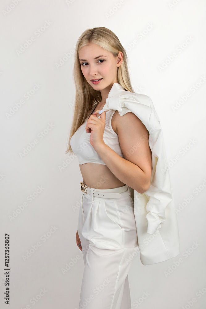 Portrait of a beautiful and smiling young woman in a white top and trousers Portrait of a beautiful and smiling young woman in a white top and trousers