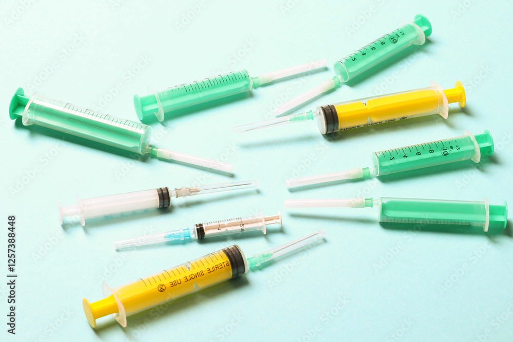 Top view of medical syringes with needles at blue background with copy space. Injection treatment concept Top view of medical syringes with needles at blue background with copy space. Injection treatment concept