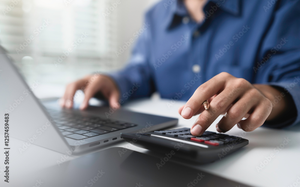 Close up businessman hand using calculator to budgeting and tax calculation monthly expenses. budget management and accounting on table. Business finance accounting banking concept. Close up businessman hand using calculator to budgeting and tax calculation monthly expenses. budget management and accounting on table. Business finance accounting banking concept.