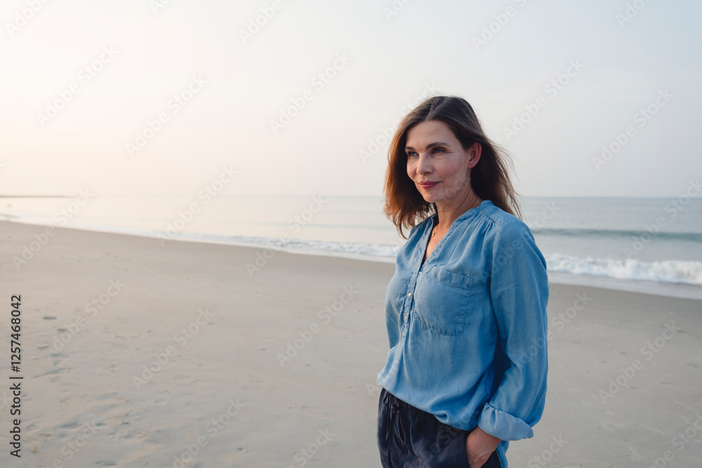 Beautiful woman with hands in pockets standing at beach Beautiful woman with hands in pockets standing at beach