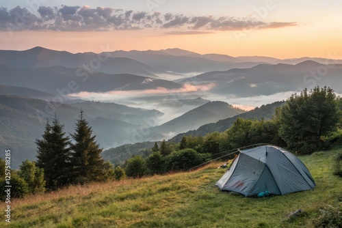 Serene sunrise over misty mountains with a tent in the foreground, capturing nature's beauty