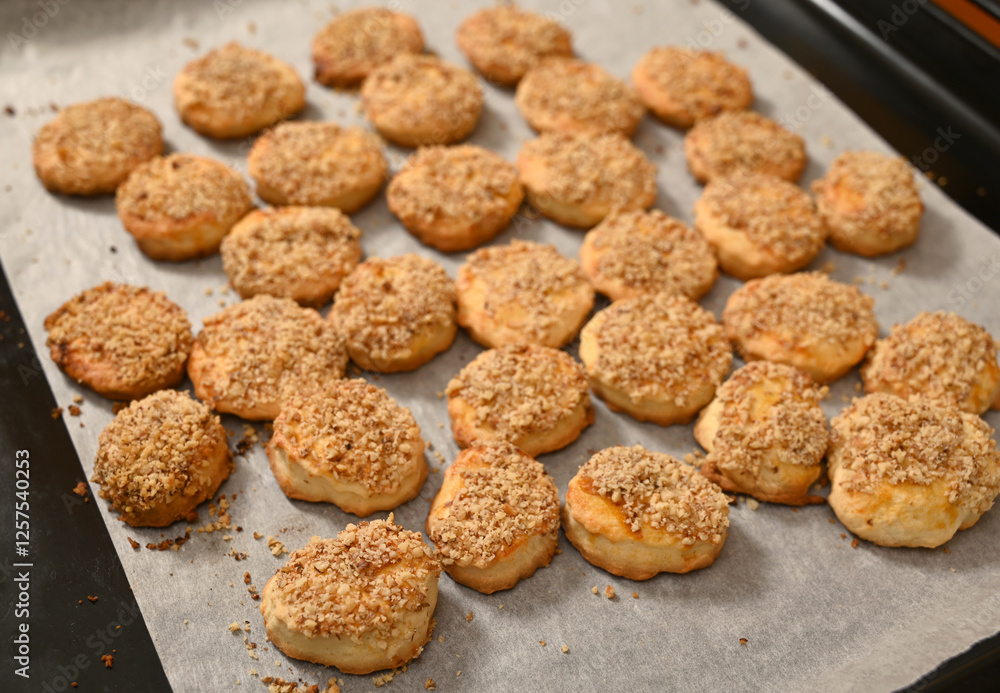 Freshly baked biscuits topped with crunchy crumbs cooling on a baking tray in a cozy kitchen