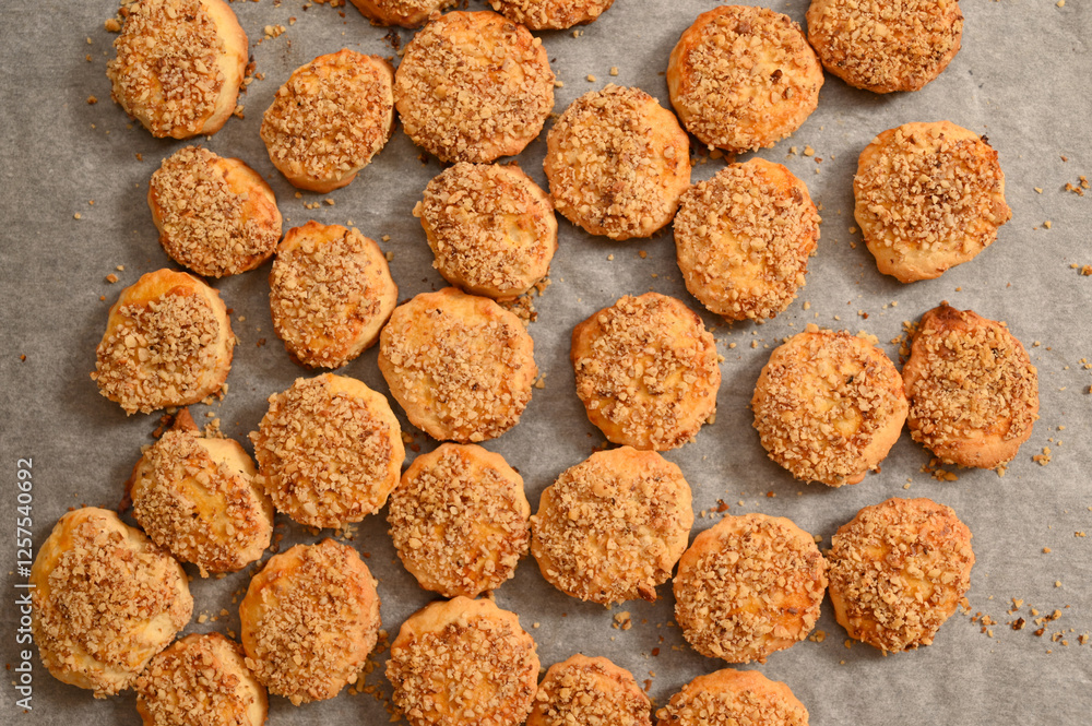 Freshly baked cookies with crumbly topping cooling on a parchment-lined surface in a cozy kitchen
