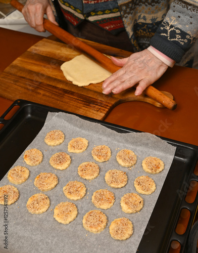 Obraz na płótnie Baking cookies with rolled dough on a wooden surface in a cozy kitchen during the evening w salonie