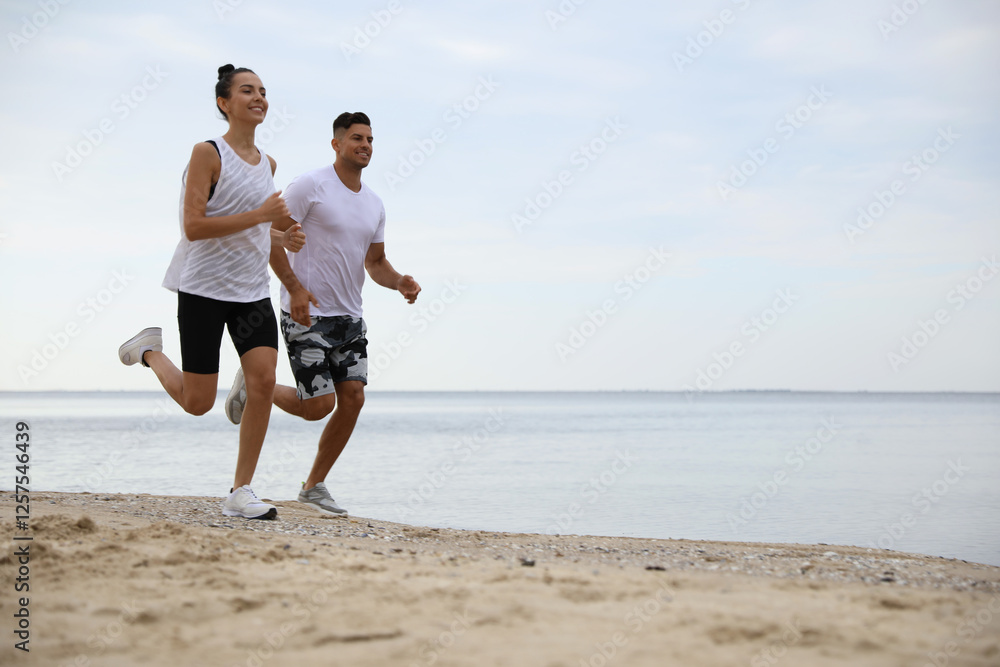 Couple running together on beach, space for text. Body training Couple running together on beach, space for text. Body training