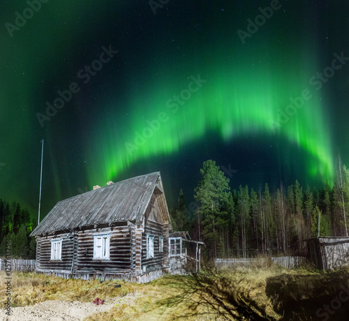Northern lights over a wooden house