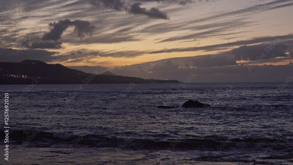 Sunset over ocean with dramatic clouds and mountains Sunset over ocean with dramatic clouds and mountains