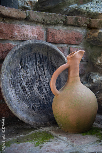 The  view of an earthenware jug and an old wooden plate