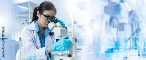 Asian Researcher using a microscope in the clinical lab.Female Researcher working in the clinical laboratory,Medical or scientific researcher or Asian woman doctor looking at professional microscope.