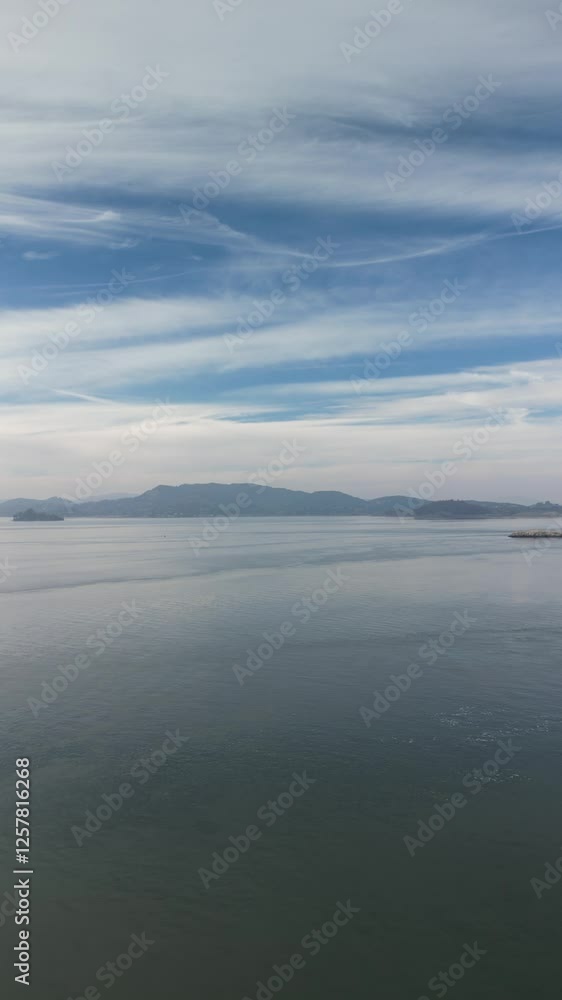 A vertical drone view of Point Molate Beach, where gentle waves meet the rugged shoreline, creating a stunning coastal scene in Richmond, California. A vertical drone view of Point Molate Beach, where gentle waves meet the rugged shoreline, creating a stunning coastal scene in Richmond, California.