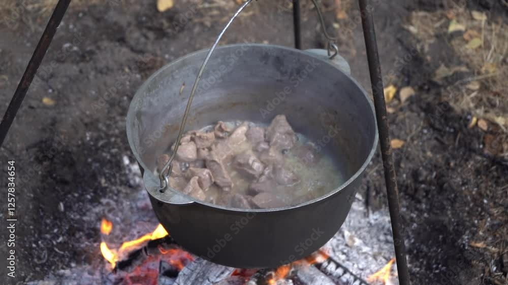 Stew meat in a cauldron over a fire. Boiling and frying. Camp fire outdoor hiking food cooking Stew meat in a cauldron over a fire. Boiling and frying. Camp fire outdoor hiking food cooking
