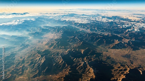 A breathtaking high-altitude view of a vast mountain range, showcasing deep valleys and endless ridges afar photo