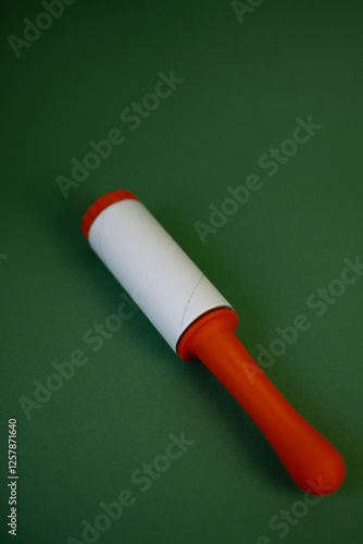 3D printed orange lint roller on green background