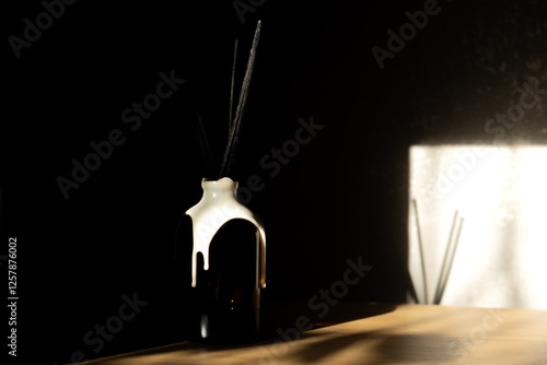 Glass bottle aroma diffuser on wooden shelf