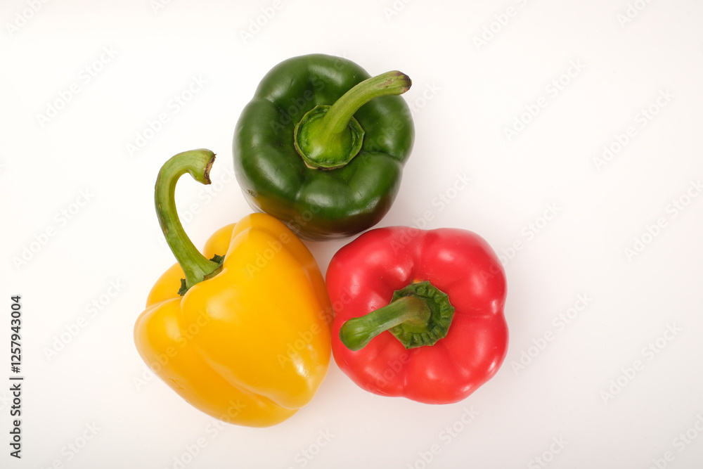 Red, yellow and green peppers on the white background Red, yellow and green peppers on the white background