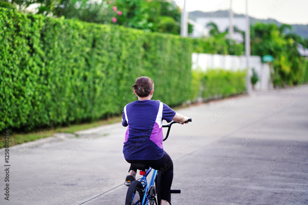 Obraz premium woman cycling bicycle in village road