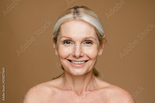 Fotografía Good-looking beautiful middle-aged woman posing in studio over grey background