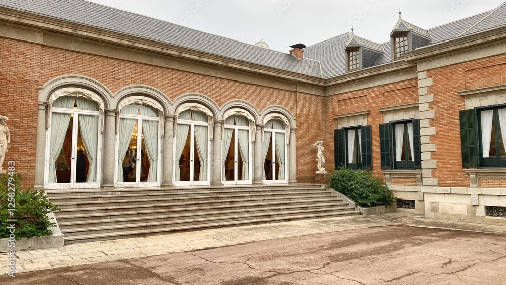Fototapeta premium Palace in Barcelona with ornate brick and stone walls, arched windows and decorative architectural features. King's residence in his official visits to the city