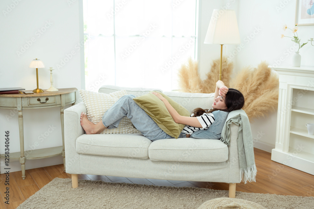 Fototapeta premium Young Asian woman relaxing in living room at home