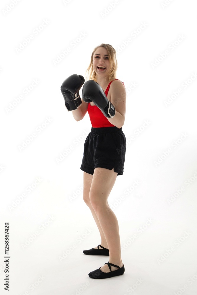 Young woman practicing boxing techniques in a studio with bright lighting during a training session Young woman practicing boxing techniques in a studio with bright lighting during a training session