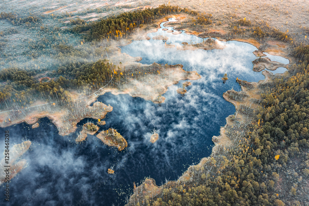 Drone panorama on tiny isles in lake in colorful sunrise colors. Top down view on swamp with isle. Sustainable ecosystem of wetlands.