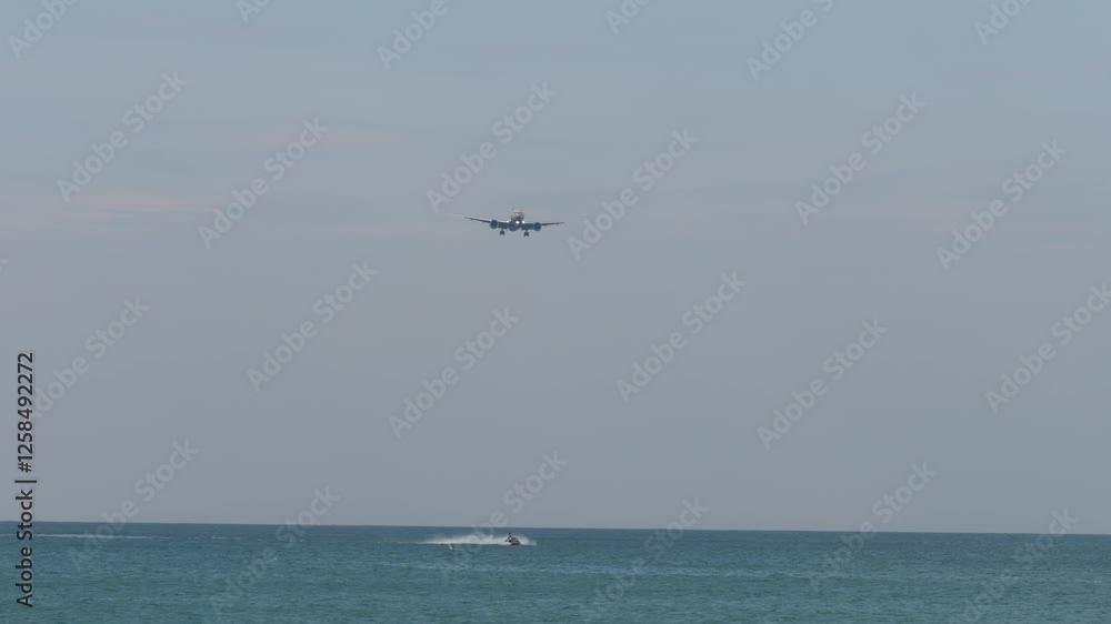 Jet plane approaching landing over the sea. Jet ski racing on the waves. Travel concept Jet plane approaching landing over the sea. Jet ski racing on the waves. Travel concept