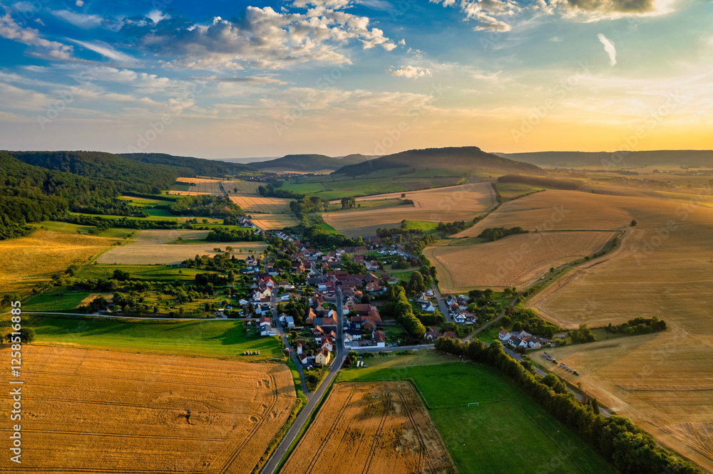 Vibrant German Village Nestled in a Valley Surrounded by Lush Greenery and Picturesque Mountains on a Bright Sunny Day