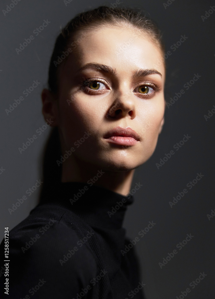 Thoughtful young woman with a smooth complexion and sleek hairstyle, wearing a black turtleneck, posing against a dark background. Reflective and elegant mood. Thoughtful young woman with a smooth complexion and sleek hairstyle, wearing a black turtleneck, posing against a dark background. Reflective and elegant mood.