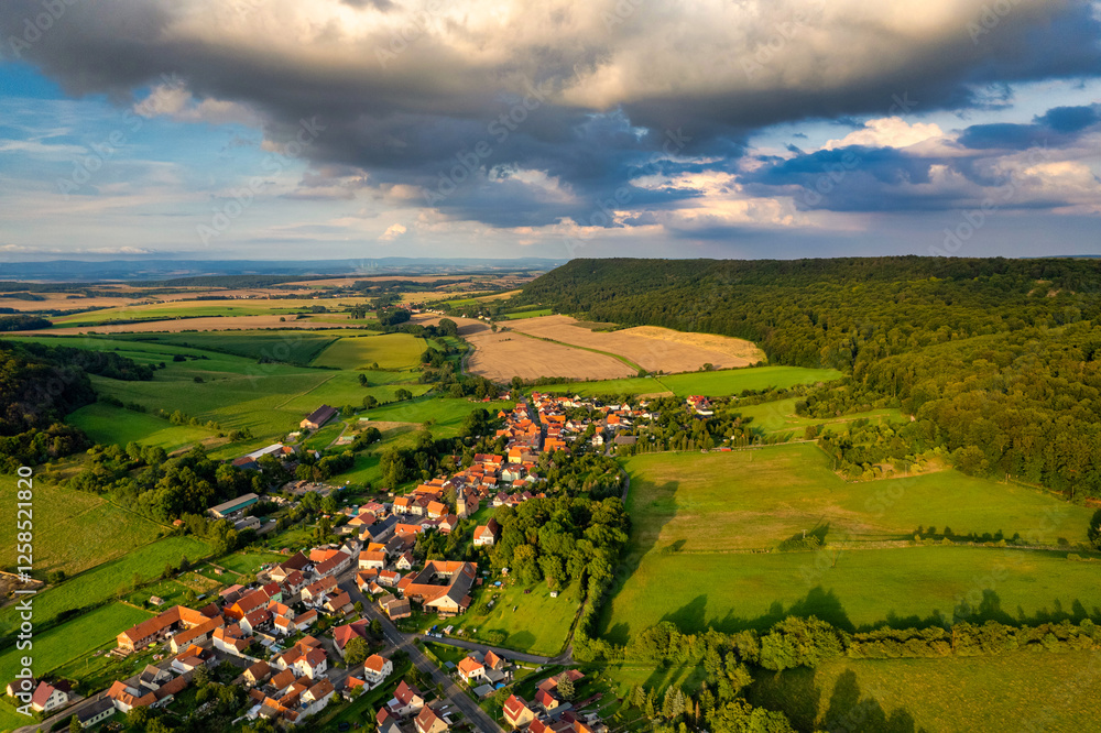 Vibrant German Village Nestled in a Valley Surrounded by Lush Greenery and Picturesque Mountains on a Bright Sunny Day