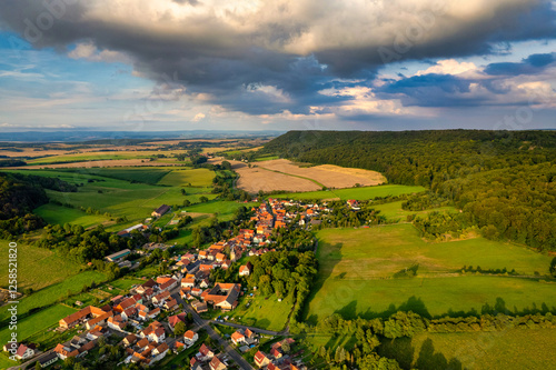 Obraz na płótnie Vibrant German Village Nestled in a Valley Surrounded by Lush Greenery and Picturesque Mountains on a Bright Sunny Day w salonie